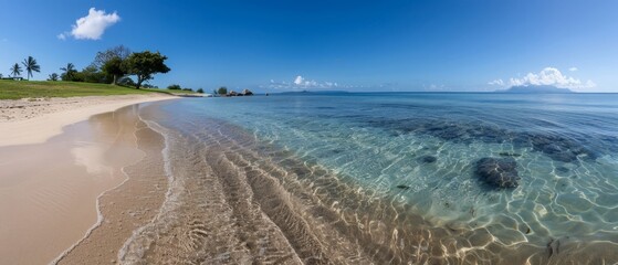  A sandy beach with clear blue water On one side, a grassy hill; on the other, another grassy hill