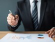 © sorrakrit - Close-up of a businessman's hand pointing at a document with a pen.
