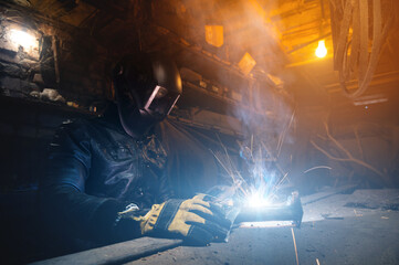 Close up of welder working on welding iron in old garage, workshop