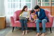 © Verin - family lifestyle concept, mother working on laptop while father playing with kid in the living room