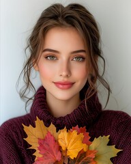 Wall Mural - A woman in a purple sweater holding a bunch of autumn leaves