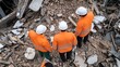 © ชัยธวัช ผาผง - Rescue workers assess damage at a construction site after a collapse, wearing safety gear and helmets amidst debris.