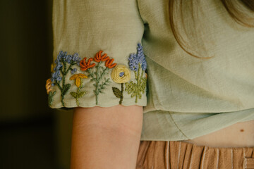 the sleeve of the shirt is hand-embroidered with flowers