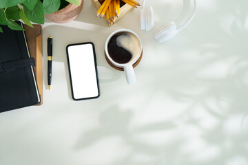 Wall Mural - Top view smart phone with empty screen, notebook and coffee cup on office desk. Copy space for your text.
