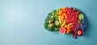 © Nanda - Brain shape made of fresh fruits and vegetables on blue background. Healthy food for brain health, cognitive function and mental wellbeing.