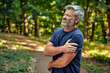 © Valerii Apetroaiei - A man in a forest is grasping his shoulder, showing discomfort and concern for himself