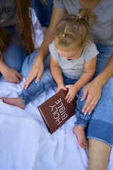 family reading the holy bible on a picnic in the garden