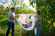 © Victoria Antre - a family of four is playing with a white sheet in the garden, a toddler wants to flutter the sheet