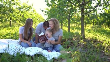 Wall Mural - a  family reading the holy bible on a picnic in the garden