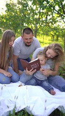 Wall Mural - a  family reading the holy bible on a picnic in the garden