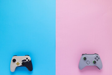 two game pads looking up on a pink and light blue background, gaming showdown, minimalist design