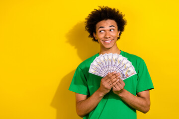 Sticker - Photo of attractive funny guy wear green t-shirt rising cash fan looking emtpy space isolated yellow color background