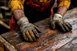 © Kitta - Crafting Wood: A Worker’s Hands Engaged in the Art of Rustic Creation Amidst Oily Surfaces and Gritty Surroundings