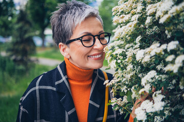 Canvas Print - Photo of pretty aged lady closed eyes enjoy smell flowers walk fresh air street outdoors