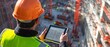 © indyntk - Japanese engineer using a tablet to monitor construction progress with a site full of equipment and workers highlighting modern technology integration and project oversight
