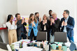 © Lomb - Diverse team celebrating project completion: multigenerational professionals in vibrant office meeting
