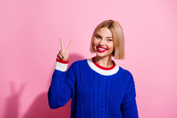 Poster - Photo portrait of pretty young girl showing v-sign empty space dressed stylish blue outfit isolated on pink color background