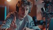 © Aytaj - One man caucasian male blogger or vlogger gesticulating while streaming video podcast in broadcasting studio use microphone and headphones famous influencer shooting video for channel podcast