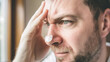 © Bonsales - Man with a worried expression holding his forehead, nose covered with a pore strip. Detailed view of facial skin and stubble