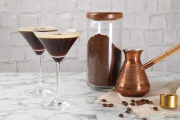 Wall Mural - Refreshing cocktails in glasses, beans, cezve and ground coffee on white marble table