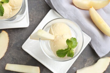 Wall Mural - Scoops of melon sorbet with mint in glass dessert bowls and fresh fruit on grey table, flat lay