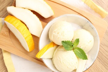 Wall Mural - Scoops of tasty melon sorbet with mint in bowl and fresh fruit on wooden table, flat lay