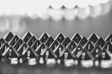 Close-up macro of sewing studs arranged in symmetrical rows in black and white abstraction abstract