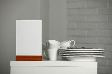 Sticker - Menu holder and clean dishware on white table indoors