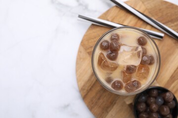 Poster - Tasty milk bubble tea in glass, tapioca pearls and straws on white marble table, top view. Space for text