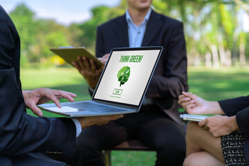 Wall Mural - Group of asian business people planning on environmentally friendly development plan on laptop screen and sustainable technology project for greener future, outdoor eco office at natural park. Gyre