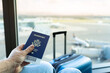 © kieferpix - Hand holding USA passport at airport, travel holiday vacation concept