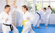 © JackF - Active young female attendee of karate classes fighting with middle-aged man during workout session