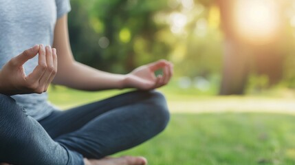 Poster - A woman is sitting on the grass and practicing yoga