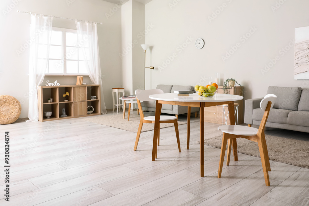 Interior of light room with dining table and sofas