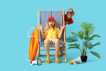 Wall Mural - Shocked little children lifeguards with ring buoy and megaphones sitting on deckchair against blue background