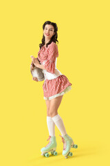 Wall Mural - Young pin-up waitress on roller skates with tray on yellow background