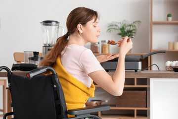 Poster - Young woman in wheelchair tasting meal at home