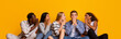 © Prostock-studio - International group of students gossiping over yellow studio background, student lifestyle