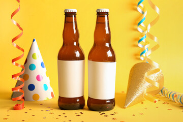 Wall Mural - Bottles of cold beer with party hats and confetti on yellow background