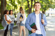 © Prostock-studio - Attractive young guy student spending time with friends together after university, public park