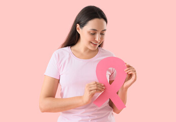 Sticker - Young woman with pink ribbon on color background. Breast cancer awareness concept