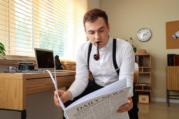 Wall Mural - Male detective with smoking pipe reading newspaper at table in office