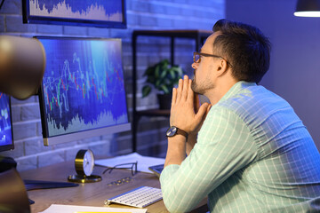 Wall Mural - Male trader working in office at night