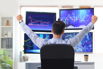 Wall Mural - Happy male trader at table in office, back view