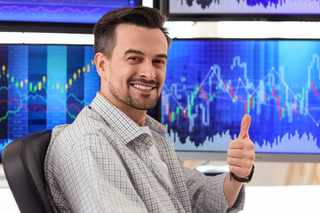 Wall Mural - Male trader showing thumb-up in office, closeup