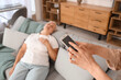 © Pixel-Shot - Woman with mobile phone and her mother having heart attack at home, closeup