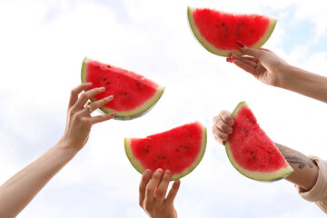 Wall Mural - Young friends with slices of watermelon on picnic in park, closeup