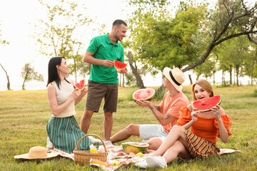 Canvas Print - Young friends with cut watermelon on picnic in park