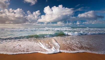 Canvas Print - waves approach from water clouds hover in the sky above sand spreads out below