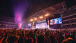 © Suralai - a live music event in a large stadium, with a massive stage illuminated by dynamic lights,